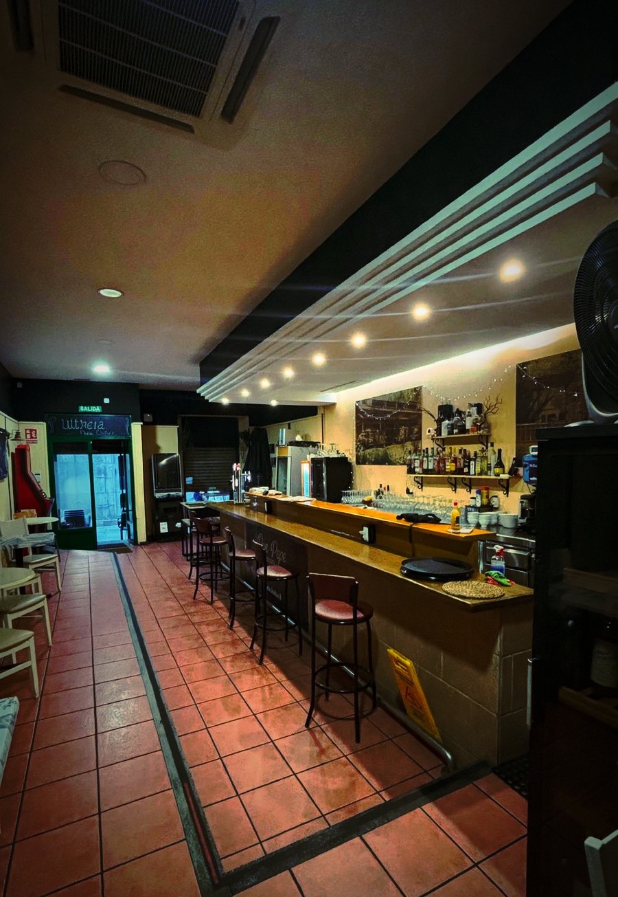 Interior de Don Pepe Original: la barra larga de madera y las mesas del comedor, en la Rúa Longa de Padrón